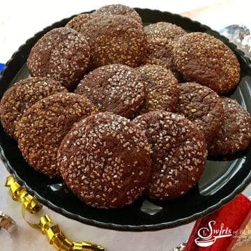 chocolate cookies with silver and gold sugars on a black plate
