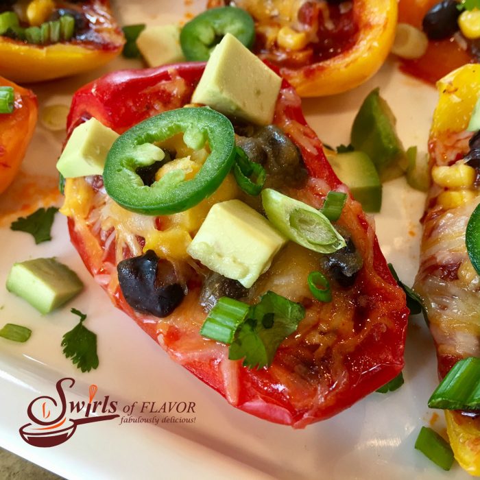 Cheesy, spicy Nacho Stuffed Peppers are seasoned with taco seasoning and brimming with salsa, black beans, corn, avocado, jalapeno and cheesy goodness! Nachos | appetizer | nachos | low fat | gluten free | cheese | stuffed peppers