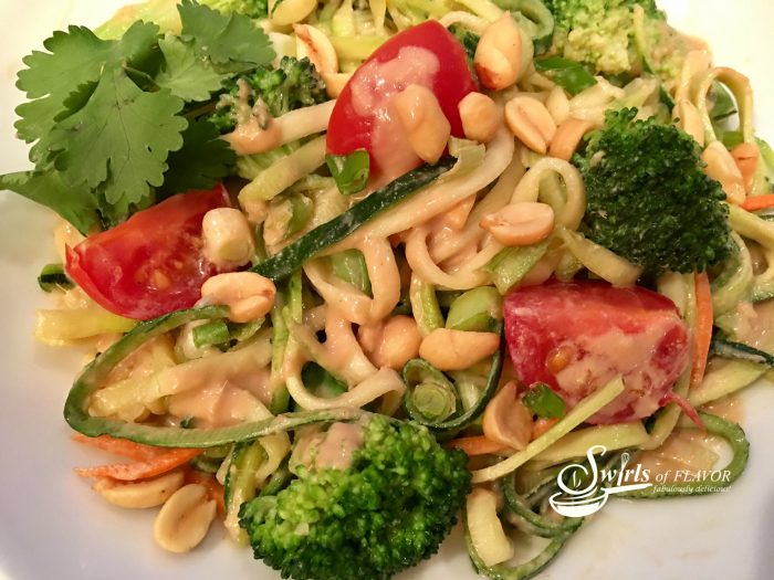 Zucchini noodles, broccoli and cherry tomatoes are coated in a silky peanut sauce and topped with crunchy scallions and peanuts! A perfect Meatless Monday dinner or side dish to your favorite meal! zucchini | zucchini noodles | zoodles | spiralizer | meatless Monday | peanut sauce | vegetables | dinner | pasta