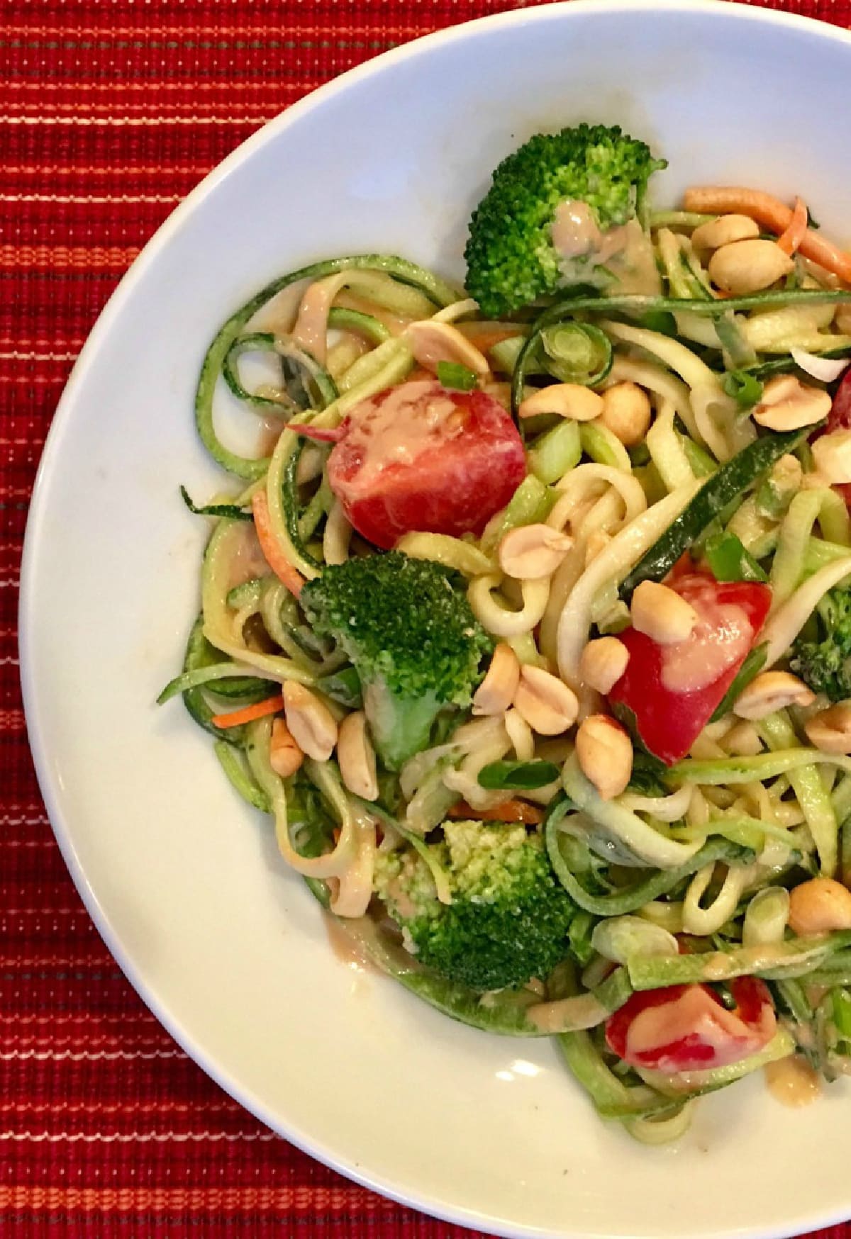 zucchini noodles with vegetables in a white bowl