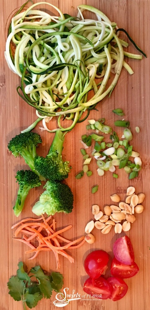 Zucchini noodles, broccoli and cherry tomatoes are coated in a silky peanut sauce and topped with crunchy scallions and peanuts! A perfect Meatless Monday dinner or side dish to your favorite meal! zucchini | zucchini noodles | zoodles | spiralizer | meatless Monday | peanut sauce | vegetables | dinner | pasta
