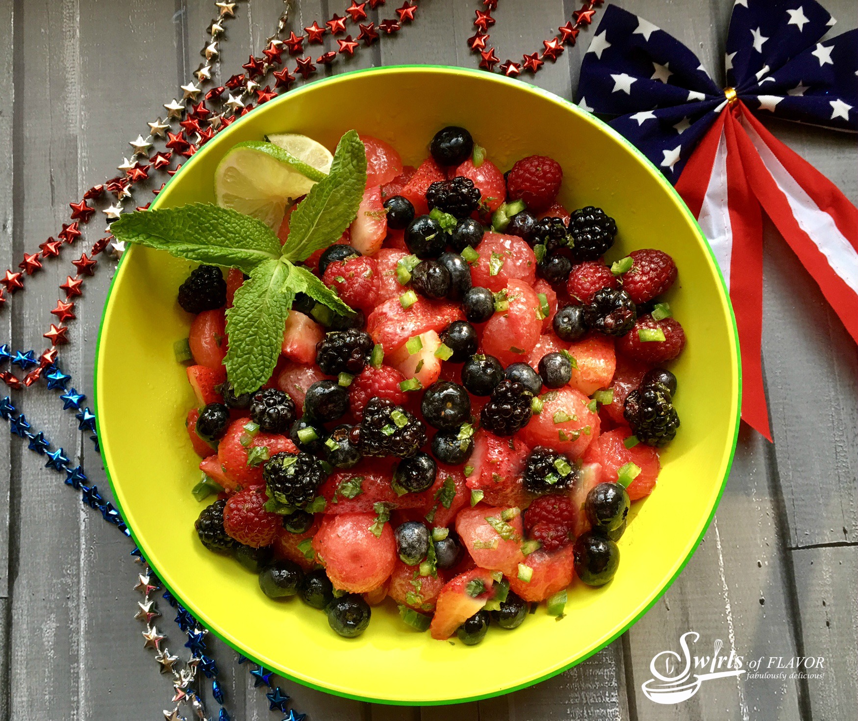 Jsummer fruit salad with watermelon, berries and fresh mint in a colorful bowl