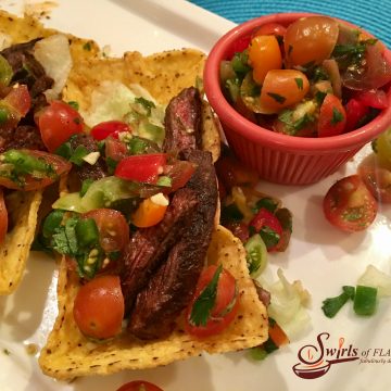 Seasoned slices of juicy skirt steak are nestled in a crunchy corn shell and topped with a lime-scented fresh heirloom tomato salsa. #tacos #TacoTuesday #steak #tacos #CincodeMayo #grilling #freshsalsa #swirlsofflavor #easyrecipe