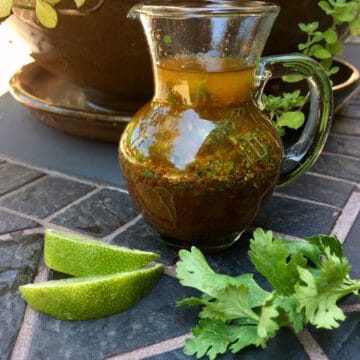 cilantro lime vinaigrette with lime wedges and cilantro sprigs