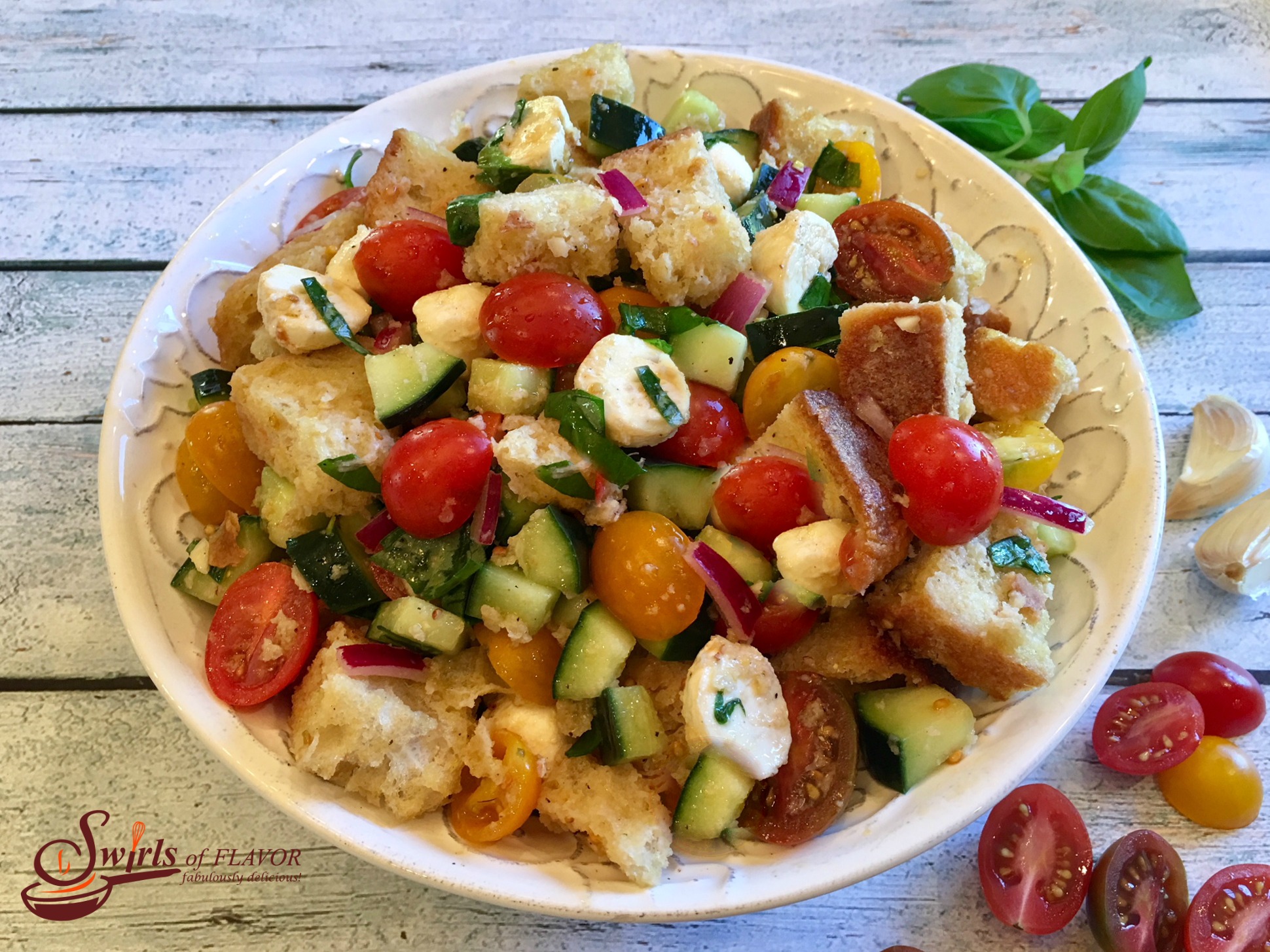 Panzanella is the classic Tuscan bread salad bursting with heirloom tomatoes, cucumber, mozzarella and fresh basil! bread salad | summer | fresh produce | tomato salad | bread salad | easy recipe | #swirlsofflavor