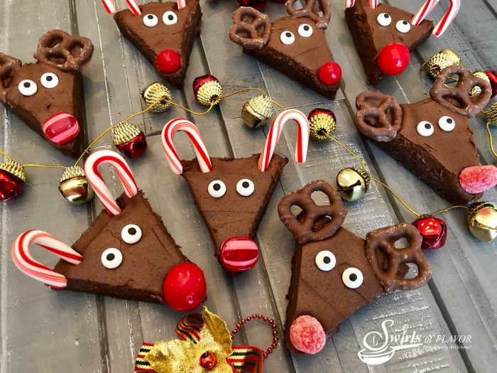 Reindeer Brownies is an easy recipe that will quickly become a holiday tradition and so much fun for kids! Fudgy homemade brownies topped with a silky-smooth cocoa buttercream frosting come to life as Rudolph with sugar eyes, candy cane antlers and a bright red candy nose, of course! #homemadebrownies #reindeer #holiday #Christmas #easyrecipe #Rudolphthe rednosedreindeer #funforkids #reindeerbrownies #cocoafrosting #candycane #swirlsofflavor