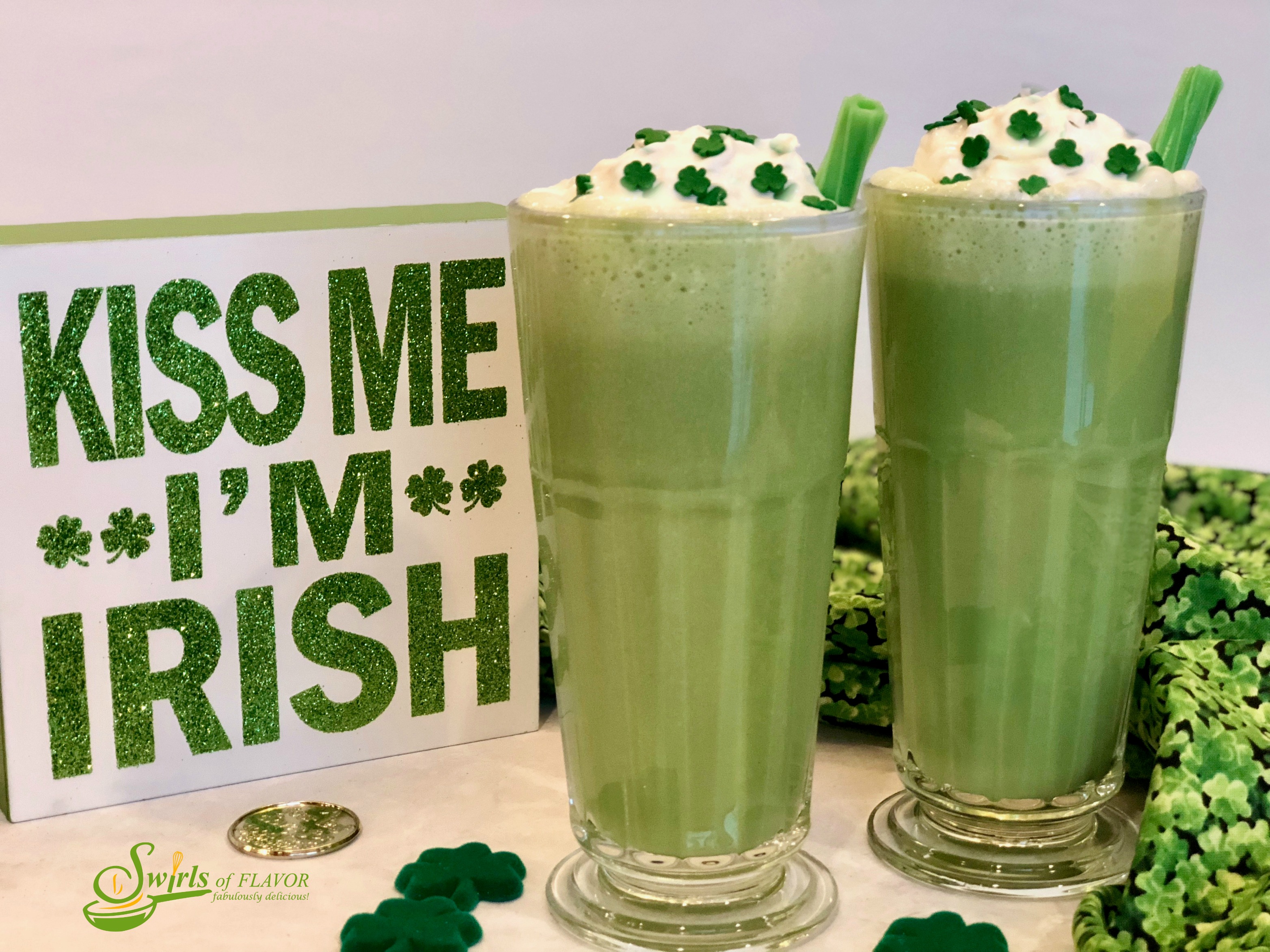 two shamrock shakes in tall glasses with green licorice straws