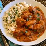 Indian Butter Chicken combines warm spices with the simple ingredients of onion, butter and garlic creating a creamy sauce with tender chicken pieces. #easyrecipe #dinner #entertaining #weeknight #tomatosauce #Indianchicken #weeknightdinner #tomato #swirlsofflavor