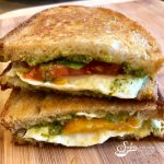 Caprese Grilled Cheese is bursting with fresh mozzarella, tomatoes, pesto, basil leaves, and of course, butter! A classic sandwich with an updated flavor! easy | grilled cheese | mozzarella | pesto | recipe | basil | tomatoes | #swirlsofflavor