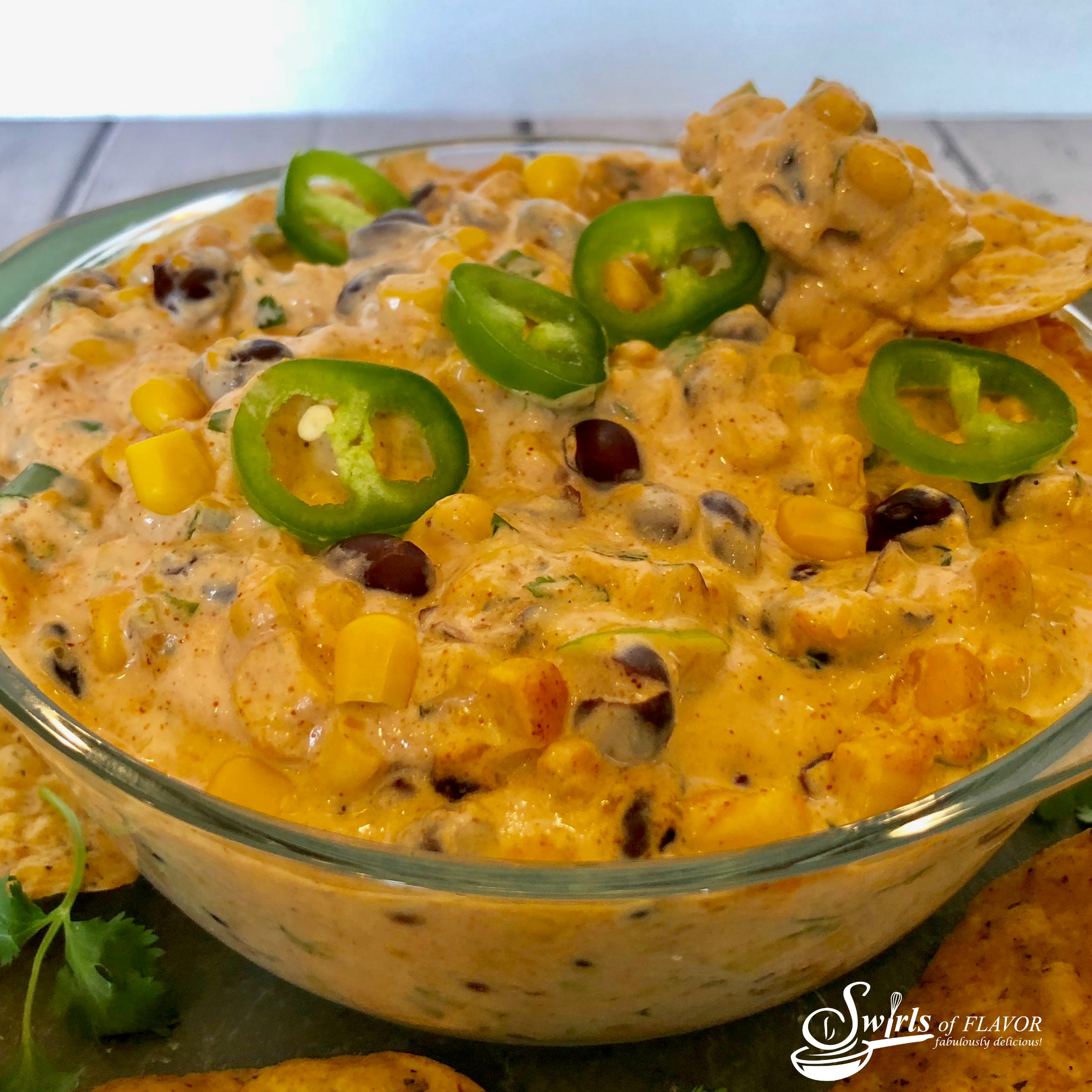 corn and black bean dip in a bowl with jalapeno slices