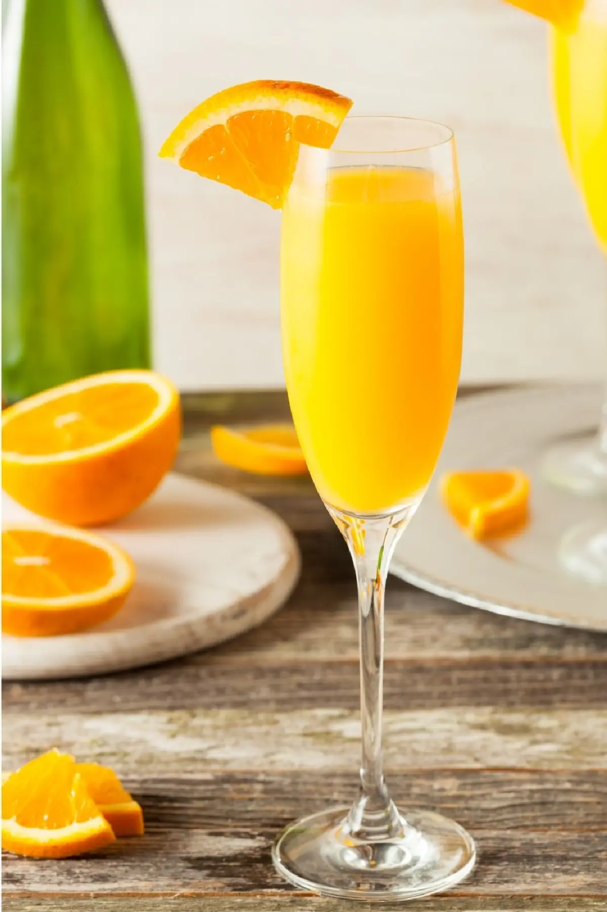 champagne flute filled with a mimosa cocktail and orange wedge garnish