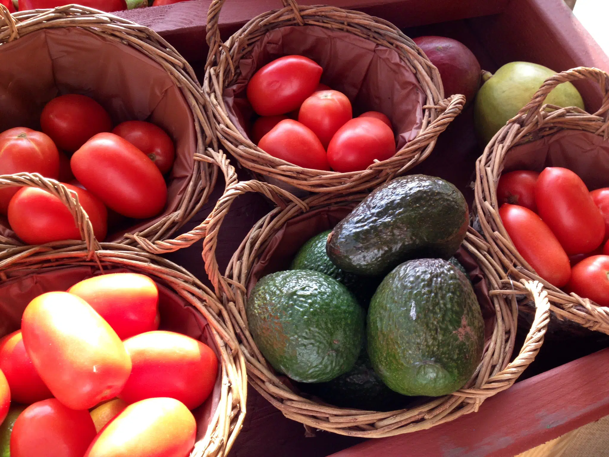 avocados and tomatoes in baskets