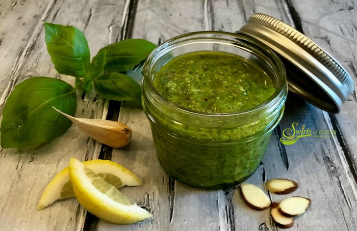 Basil Pesto is bursting with the flavors of extra virgin olive oil, fresh basil leaves from my garden, Parmesan cheese for texture and saltiness, lemon juice and zest for a bright note and the unexpected nuttiness of toasted almonds. #pesto #summer #summerrecipe #easyrecipe #basil #almonds #farmersmarket #swirlsofflavor