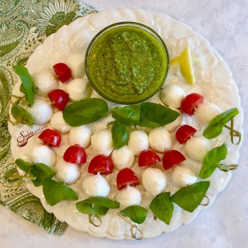 Caprese Skewers With Pesto is an easy reciipe for a homemade pesto dipping sauce served with skewers of fresh basil, mozzarella and tomatoes.