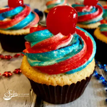 cupcake with red white and blue frosting and a cheerry on top