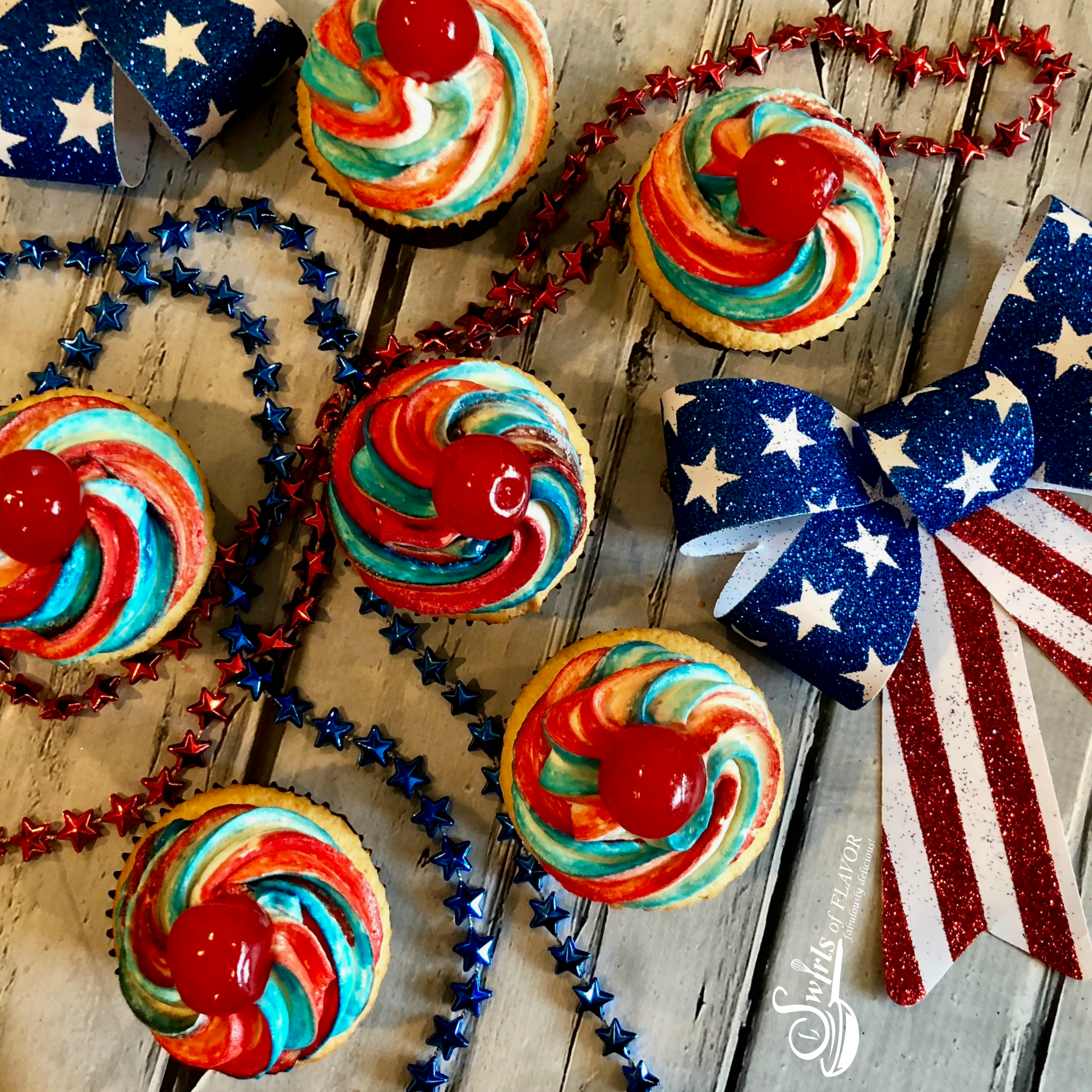 red white and blue cupcakes with beads and ribbons