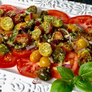 Pesto Tomato Salad combines garden fresh tomatoes, red onion and homemade pesto in an easy recipe that's bursting with fresh flavor and summertime goodness.