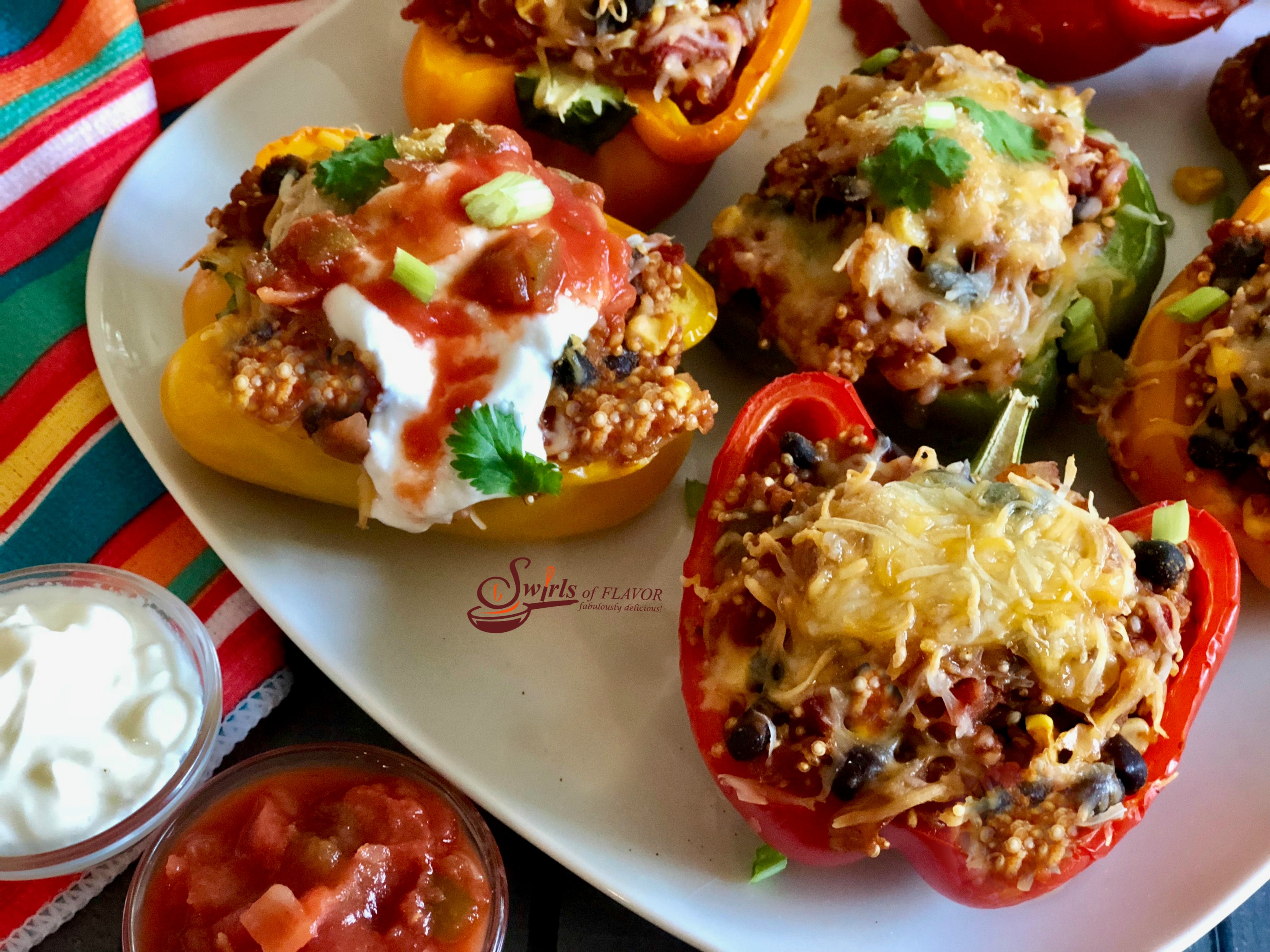 Mexican Quinoa Stuffed Peppers is an easy recipe that's perfect for a weeknight dinner and beautiful enough to serve to guests. Stuffed peppers take on a Mexican flair, bursting with a filling of quinoa, black beans, corn, tomatoes and salsa. #peppers #stuffedpeppers #quinoa #quinoastuffedpeppers #blackbeans #corn #easyrecipe #dinner #weeknightdinner #comfortfood #swirlsofflavor