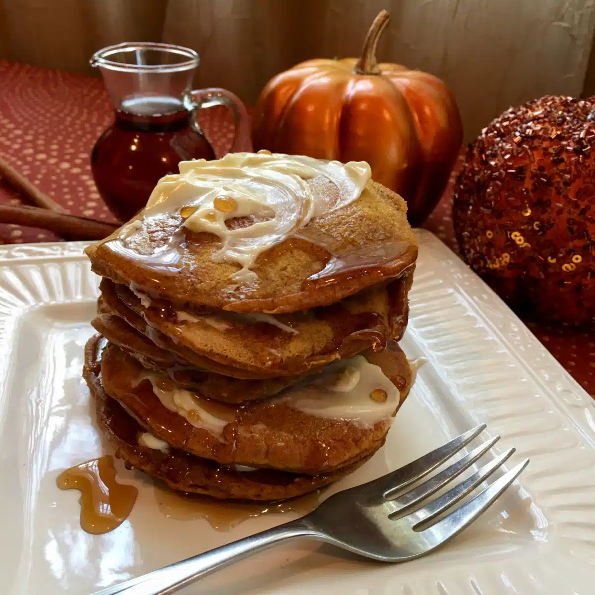 stack of pumpkin pancakes on a plate with a fork