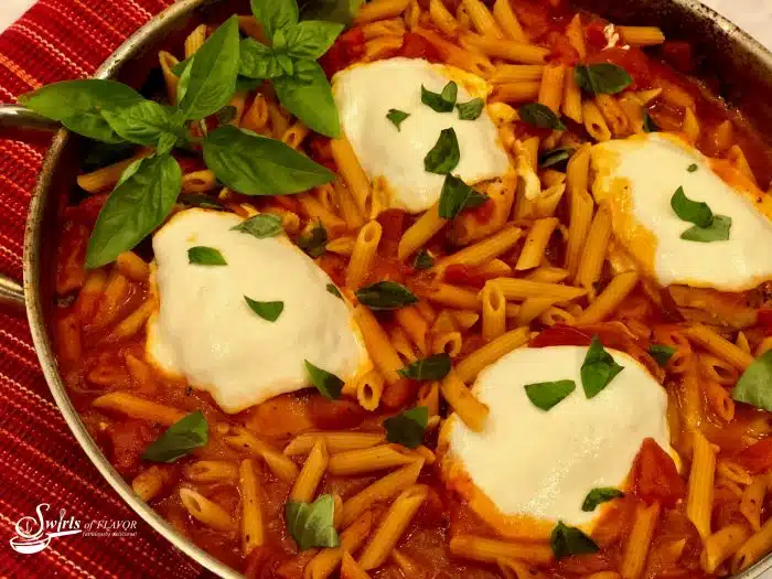 One Pot Chicken Parmesan Pasta is an easy recipe bursting with all the flavors of Chicken Parmesan, seasoned chicken, penne pasta, tomato sauce and cheese, that cook up all together for a quick weeknight dinner that's ready in just 30 minutes! #onepotdinner #chickenparmesan #skilletdinner #pasta #penne #easydinner #weeknightdinner #lessthan30minutes #cheese #onepot #swirlsofflavor                  