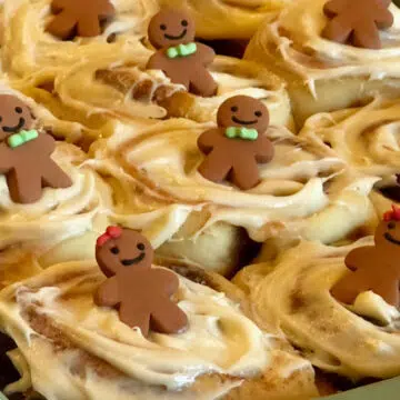 frosted gingerbread cinnamon rolls with gingerbread men decorations