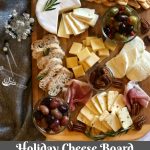 A Holiday Cheese Board is an impressive appetizer or even a dessert when it's filled with assorted cheeses, ciabiatta bread, mixed olives, roasted grapes and spiced pecans. Easy to assemble, Our Holiday Cheese Board will be the center piece of your table with it's unexpected Balsamic Roasted Grapes and Buttery Spiced Pecans! #cheeseboard #holiday #entertaining #roastedgraped #spicedpecans #cheese #newyearseve #christmas #easyrecipe #swirlsofflavor