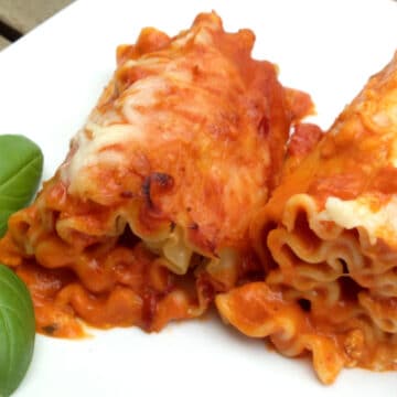 two lasagna roll ups with fresh basil