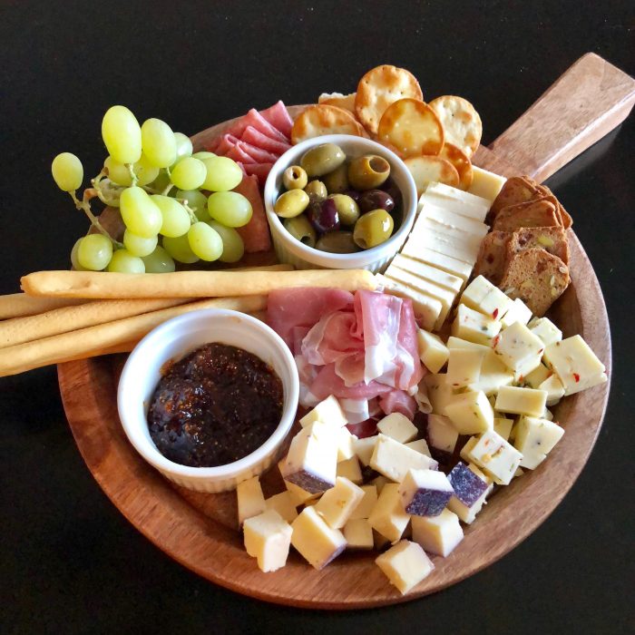 A Holiday Cheese Board is an impressive appetizer or even a dessert when it's filled with assorted cheeses, ciabiatta bread, mixed olives, roasted grapes and spiced pecans. Easy to assemble, Our Holiday Cheese Board will be the center piece of your table with it's unexpected Balsamic Roasted Grapes and Buttery Spiced Pecans!Â #cheeseboard #holiday #entertaining #roastedgraped #spicedpecans #cheese #newyearseve #christmas #easyrecipe #swirlsofflavor
