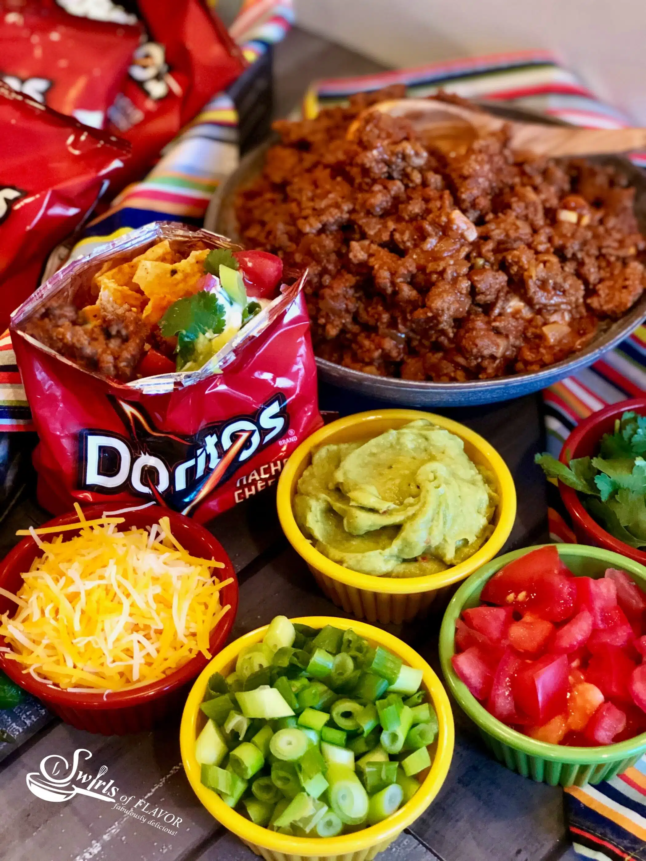 Walking Taco Bar ingredients in bowls with Doritos bag
