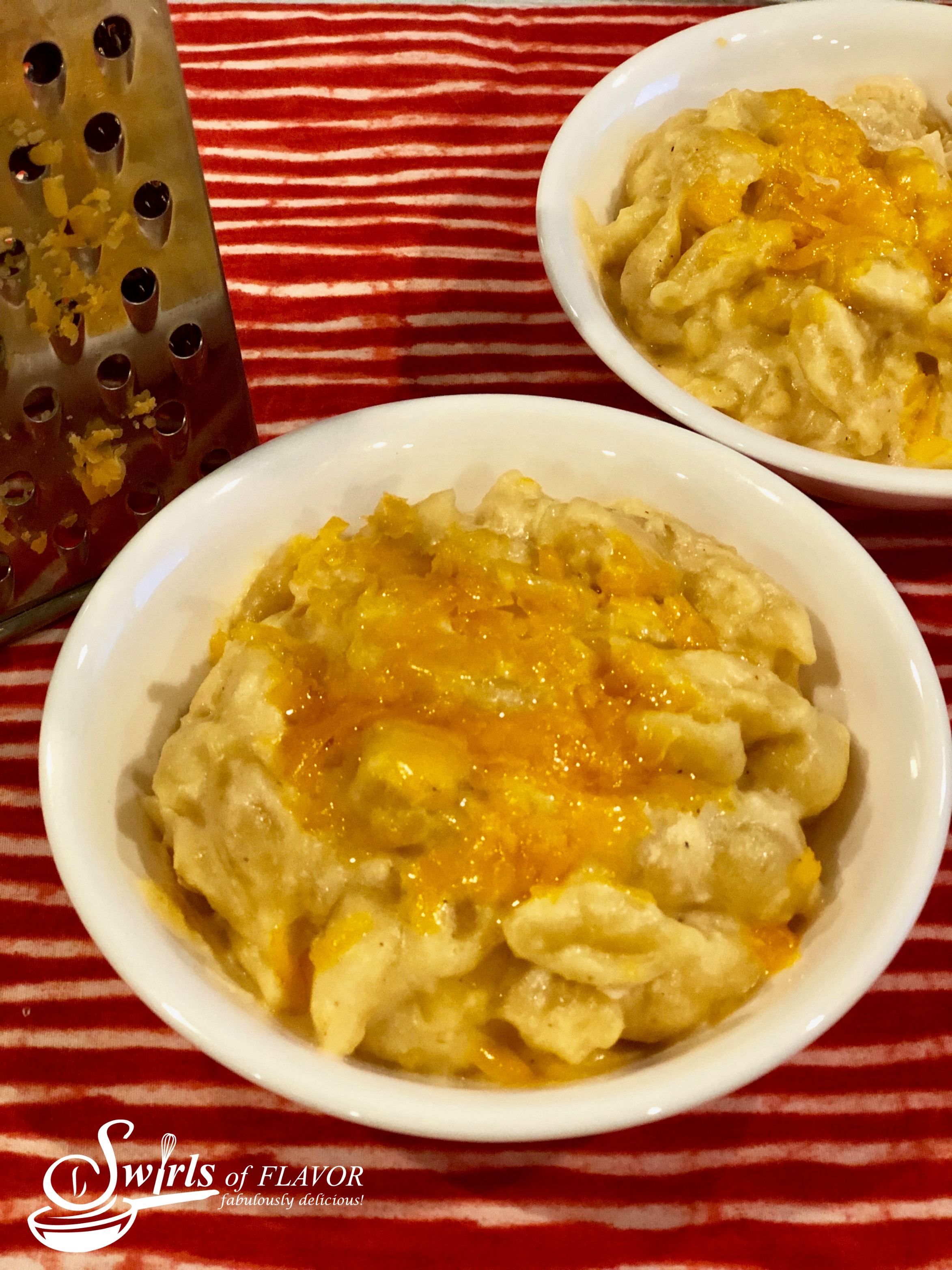 Bowls of macaroni and cheese with cheese grater