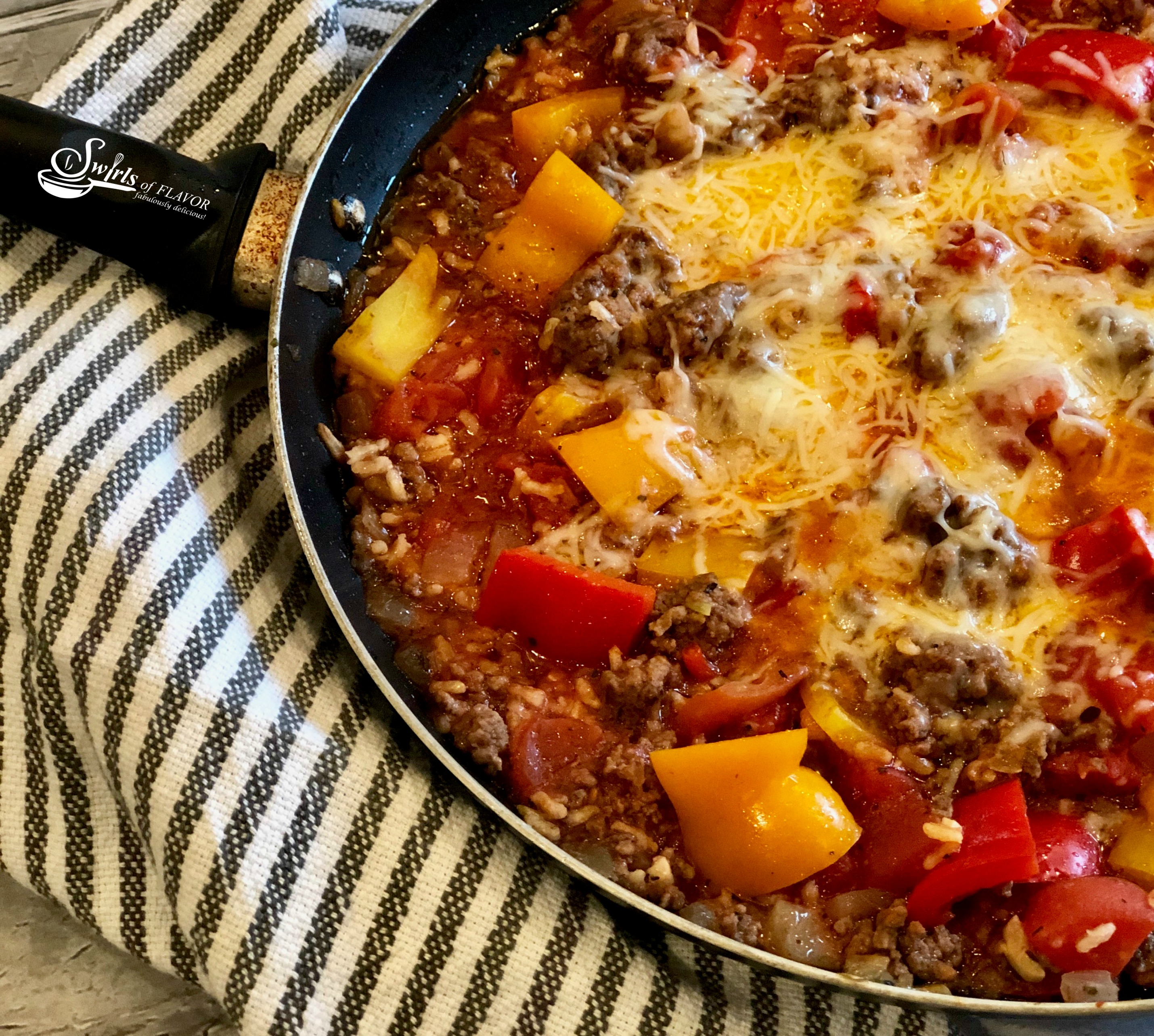 Ground beef, rice and bell peppers in a skillet