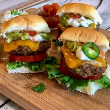Jalapeno Cheddar Burgers with toppings on wooden board