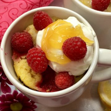Raspberry Lemon Mug Cake, "baked" in the microwave, topped with whipped topping, lemon curd and fresh raspberries, will show mom just how much you love her.