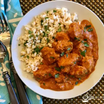 butter chicken with rice, fork and napkin