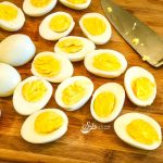 Hard boiled eggs on cutting board with knife