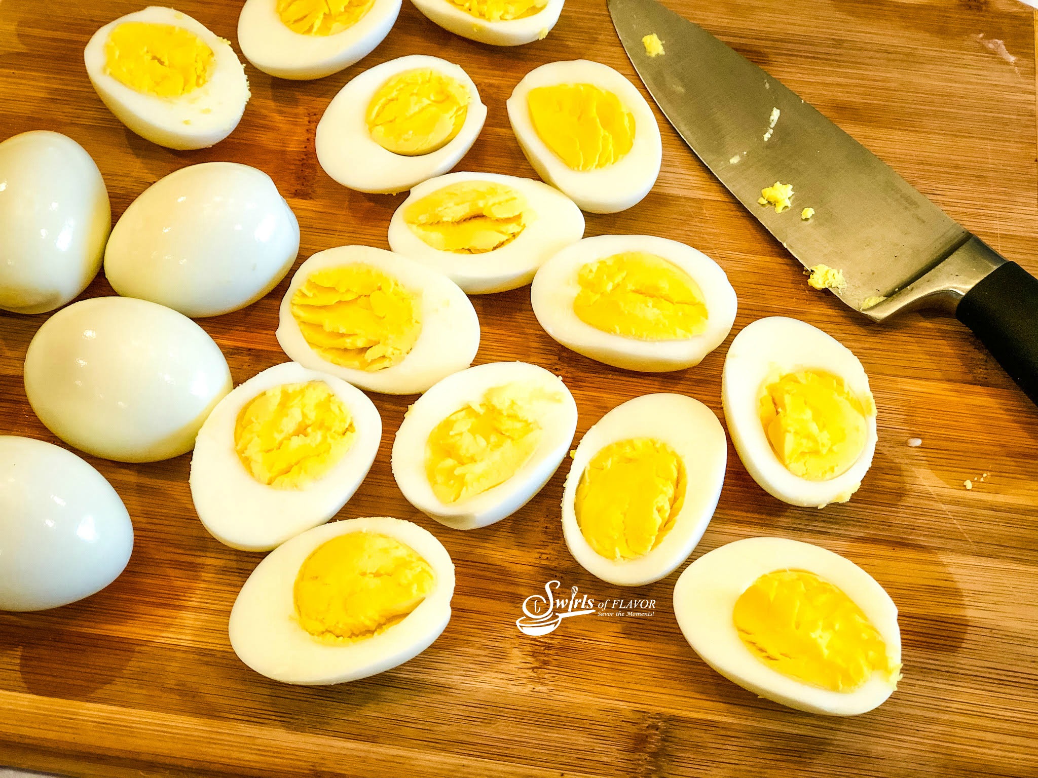 Hard boiled eggs on cutting board with knife