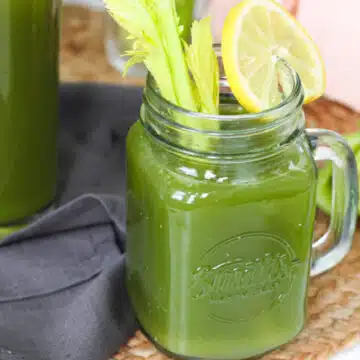 green tea smoothie in mason jar with celery and lemon garnishes