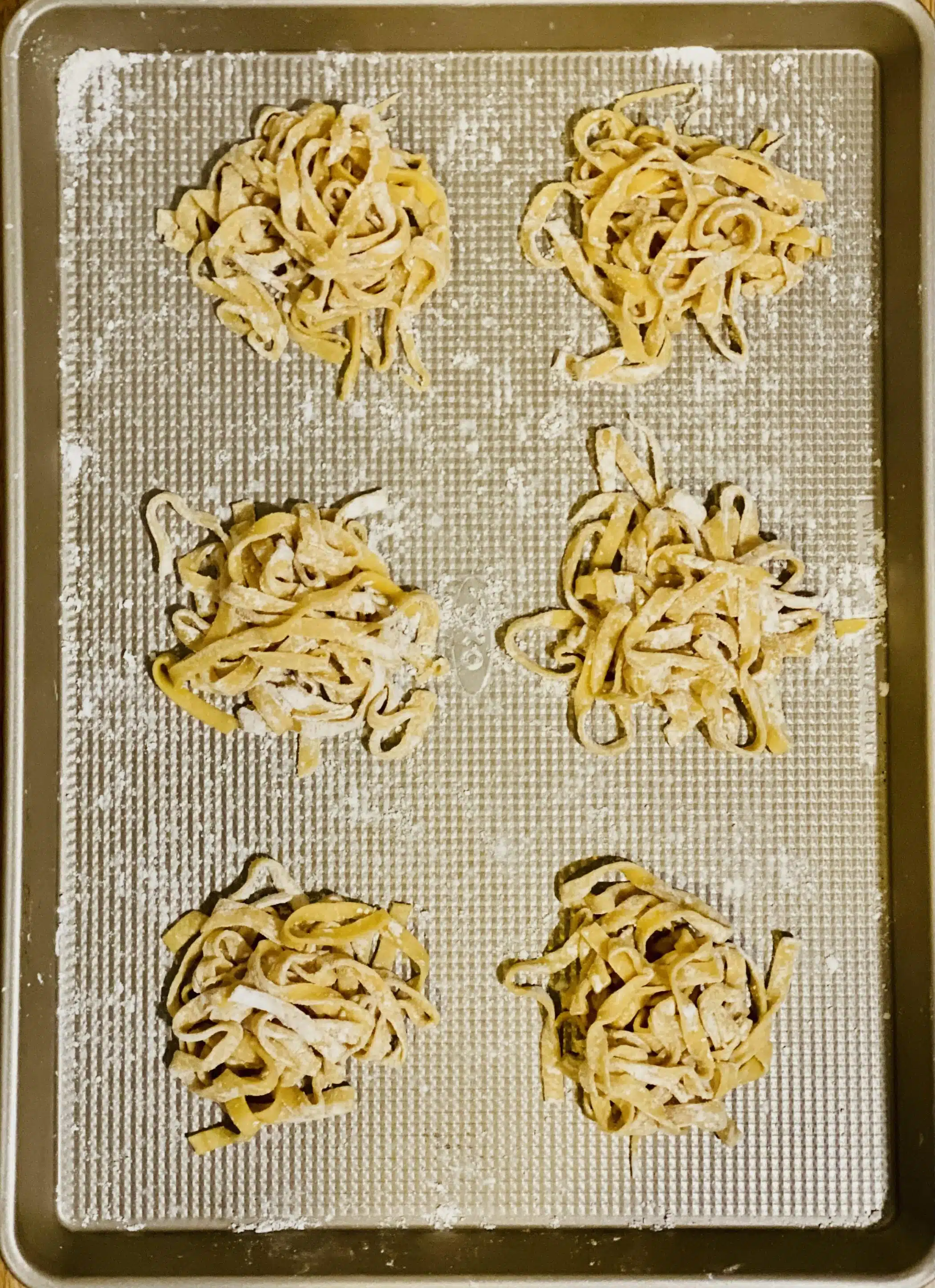 mounds og homemade pasta on a baking sheet