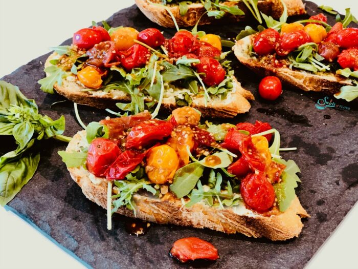 Tomato and arugula on toast on grey slate