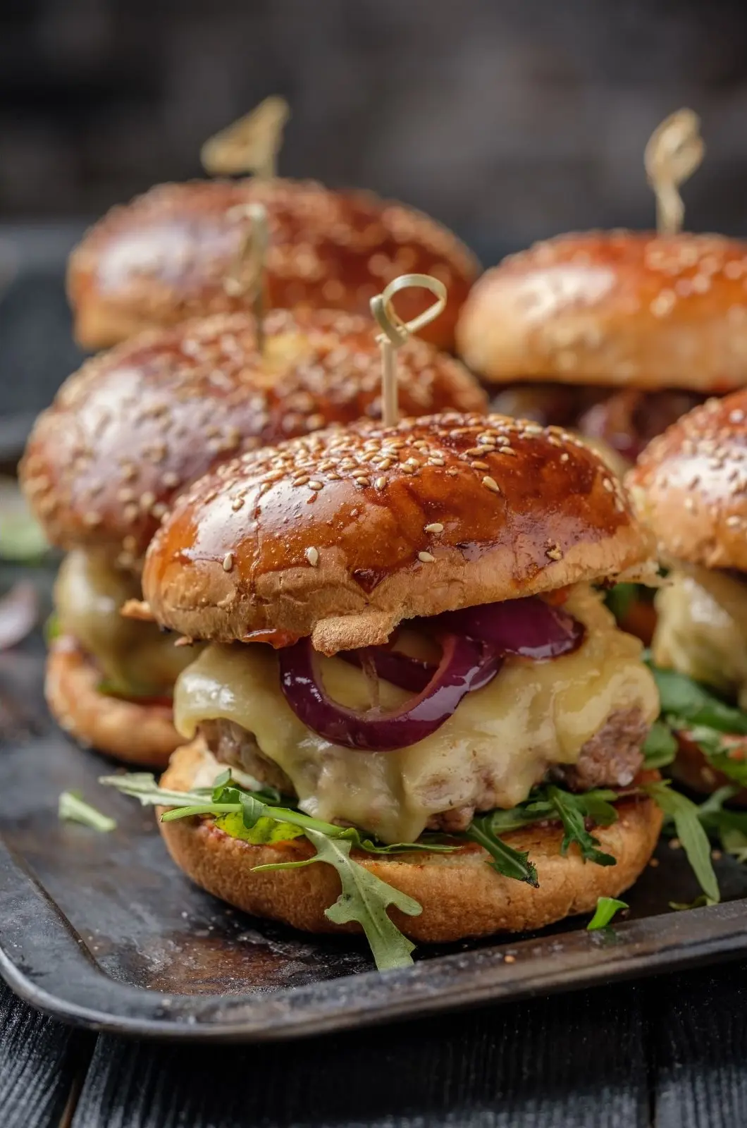 French onion hamburgers with melted cheese, red onions and arugula