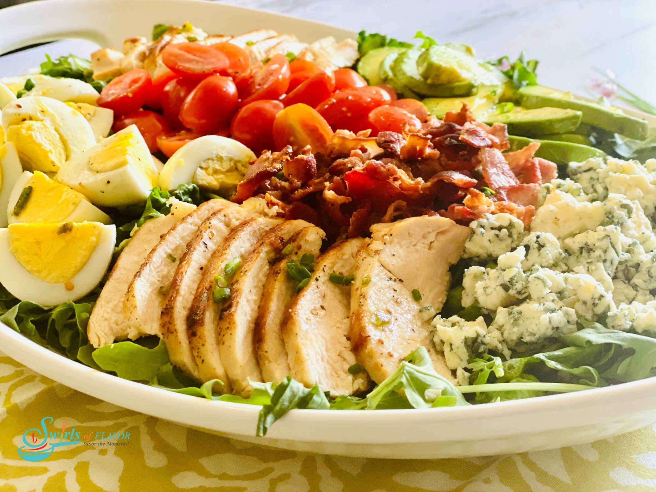 White oval platter filled with a Cobb Salad