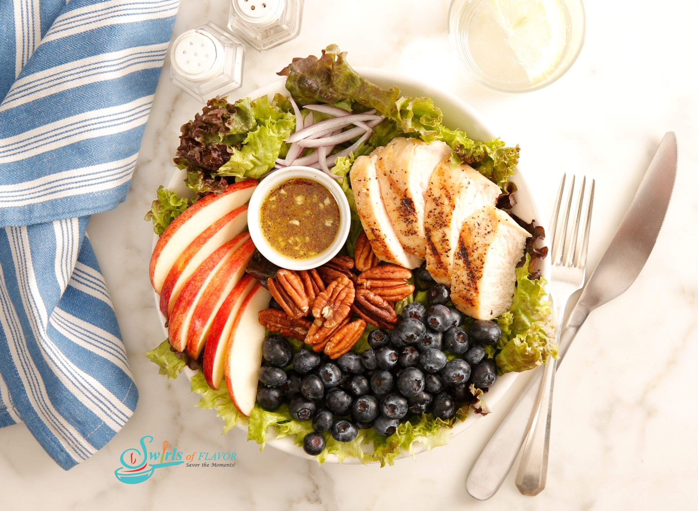 Arranged salad of chicken, blueberries, apples and honey mustard salad dressing