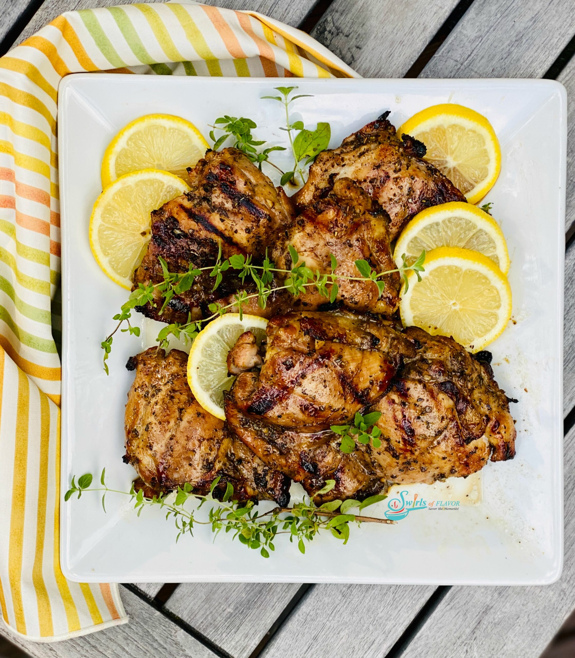 overhead photo of lemon oregano chicken with striped napkin