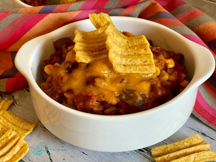 bowl of beef chili with corn chips on top