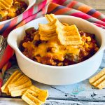 bowls of beef chili with corn chip topping