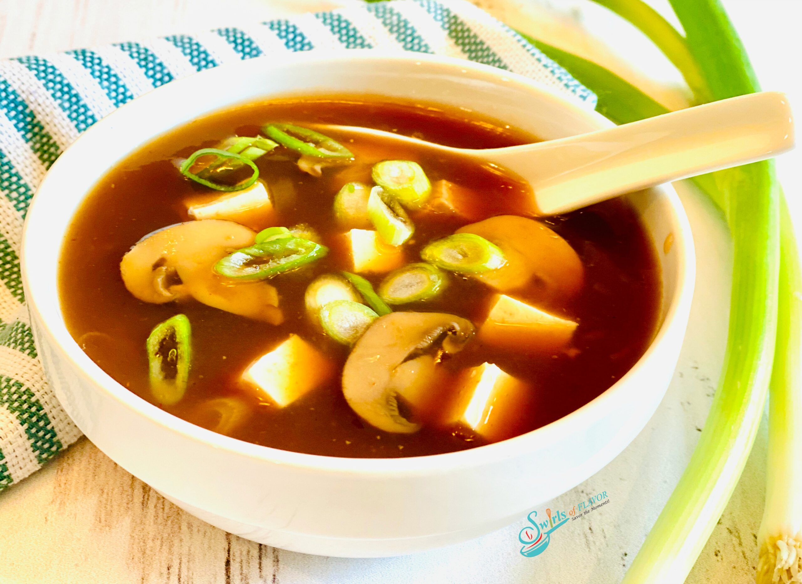 homemade hot and sour soup recipe in white bowl with spoon