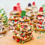 many stacked cookie Christmas trees with sprinkles and candy