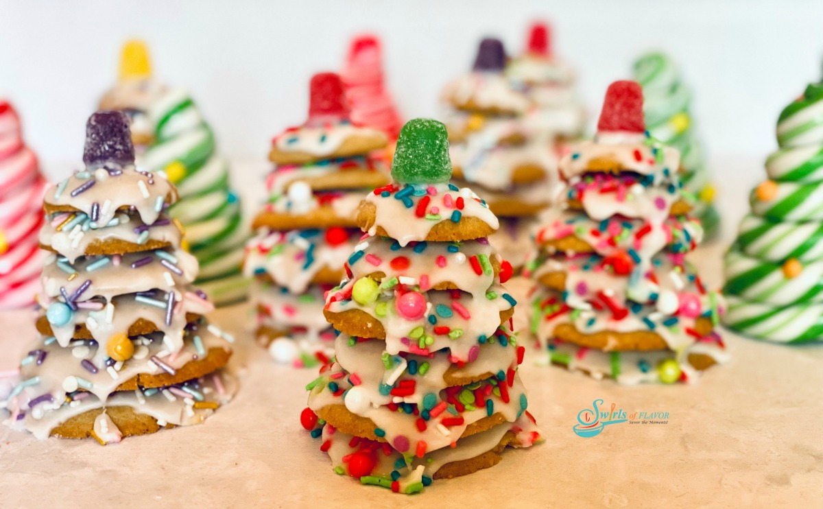 many stacked cookie Christmas trees with sprinkles and candy