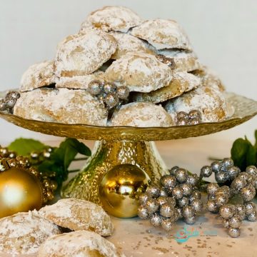 cake stand with pile of cookies with confectioners' sugar and oranments