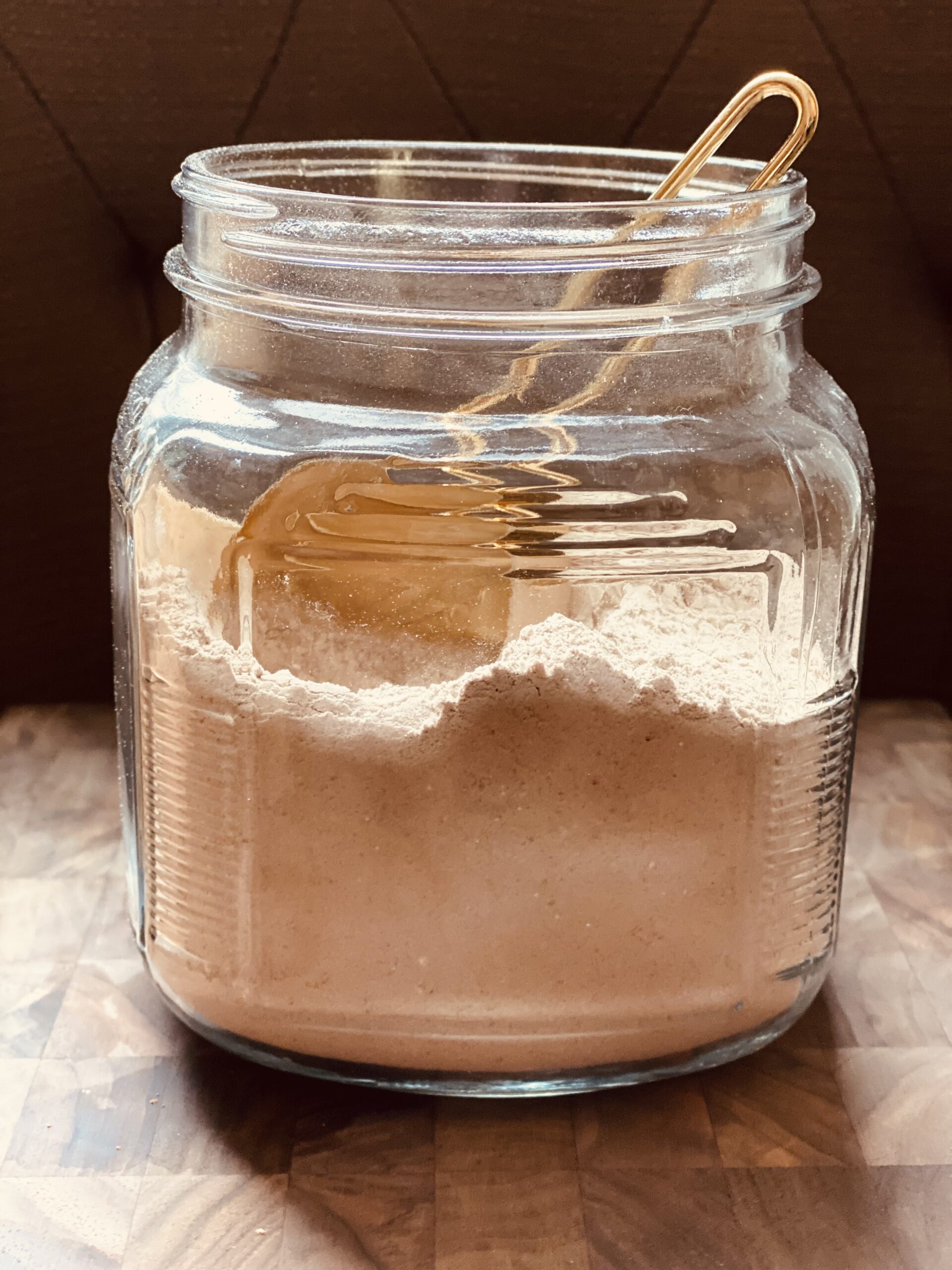 jar filled with instant hot cocoa mix and measuring cup
